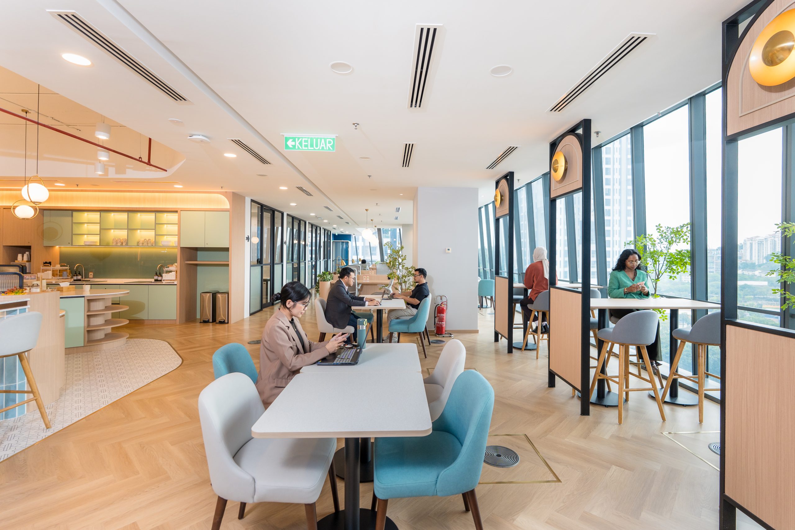 Digital nomad working remotely from a WORQ coworking space with Kuala Lumpur skyline view