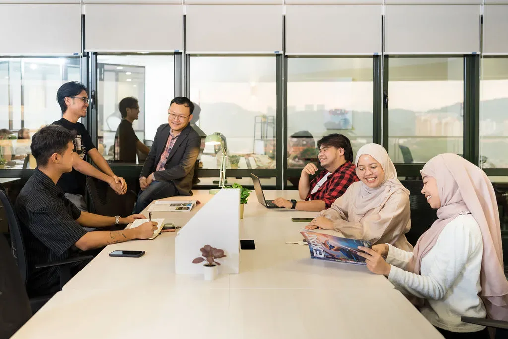 A team working together at a shared desk in a WORQ private office at Bandar Utama